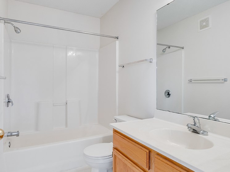 full bathroom with shower, toilet, one sink, mirror, and bright mirror lights